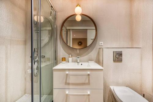 ein Bad mit einem Waschbecken und einem Spiegel in der Unterkunft Appartement neuf centre ville et plage à proximité in Saint-Raphaël