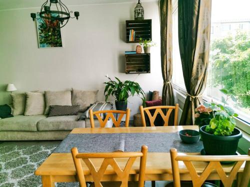 - un salon avec une table, des chaises et un canapé dans l'établissement Comfy boho-studio in Kallio., à Helsinki