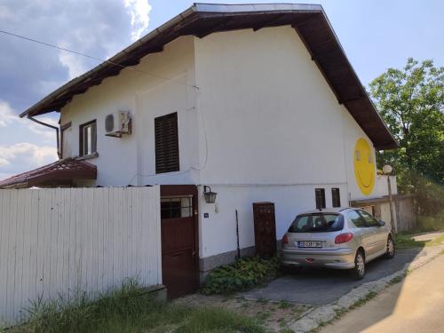 a white house with a car parked in front of it at Къща за гости Слънце Борики in Gabrovo