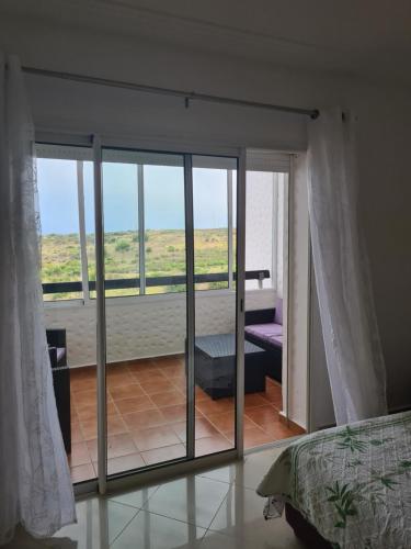 a bedroom with a sliding glass door to a balcony at Asilah Marina Golf in Asilah