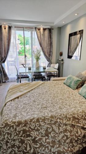 un grand lit dans une chambre avec une grande fenêtre dans l'établissement Aux portes de Paris / Studio Bord de Marne, à Bry-sur-Marne