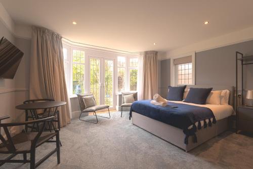 a bedroom with a bed and a table and chairs at Cransley Apart Hotel in Bournemouth