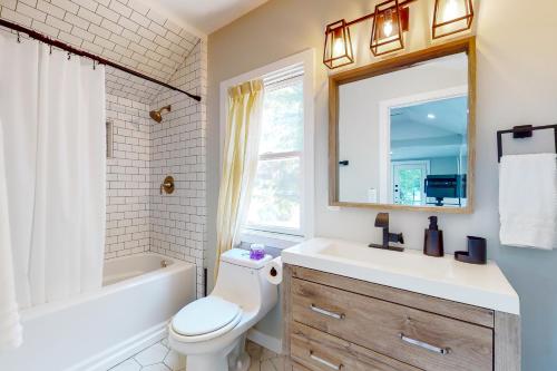 uma casa de banho com um WC, um lavatório e um espelho. em Magic on Micajah em Plymouth