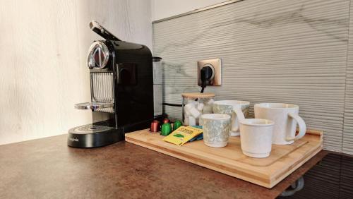 un mostrador con tres tazas de café en una tabla de cortar en Aux portes de Paris / Studio Bord de Marne, en Bry-sur-Marne