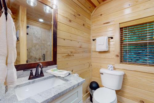 a wooden bathroom with a toilet and a sink at Down the Creek in Gatlinburg