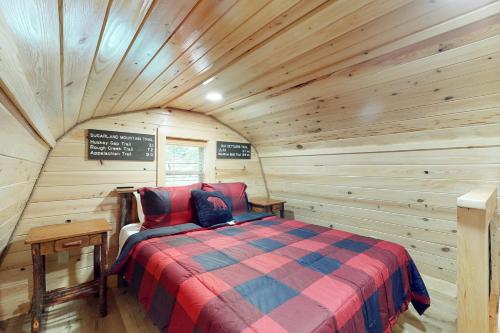 ein Schlafzimmer mit einem Bett in einer Holzhütte in der Unterkunft Down the Creek in Gatlinburg