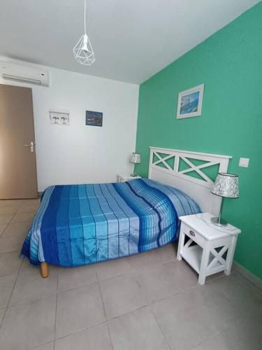 - une chambre dotée d'un lit avec un mur bleu et vert dans l'établissement L'argentière, proche plage,Résidence piscine, Tennis, parking, à La Londe-les-Maures