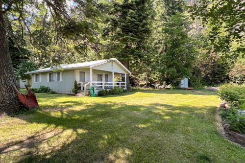 a small white house in the middle of a yard at Twin Lakes Gem in Rathdrum