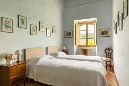 a bedroom with a white bed and a window at Borgo di Pianciano in Spoleto