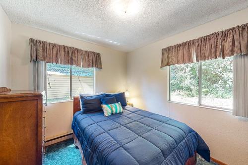 1 Schlafzimmer mit einem blauen Bett und 2 Fenstern in der Unterkunft Twin Lakes Gem in Rathdrum