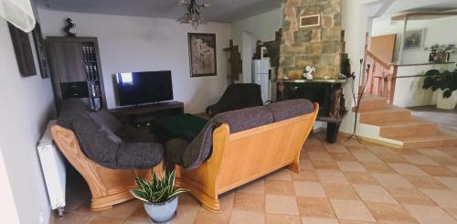 的住宿－Rychtyńska Cisza，客厅配有两张沙发和一台电视