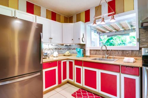 a kitchen with red cabinets and a stainless steel refrigerator at Deck, Fire Pit and Grill Port Isabel Home! in Port Isabel
