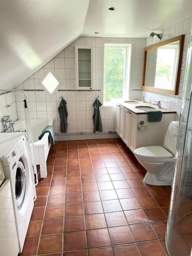 y baño con aseo y lavamanos. en Charmig villa norr om Stockholm, en Vallentuna