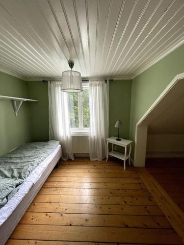 1 dormitorio con cama y ventana en Charmig villa norr om Stockholm en Vallentuna
