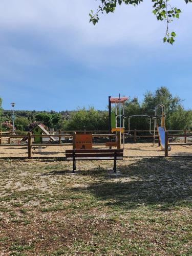 a park with a bench and a playground at Mobil-home tout confort in Sigean