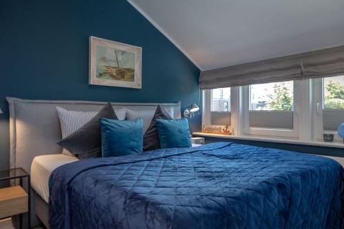 a blue bedroom with a bed and a window at Backbord in Westerland (Sylt)