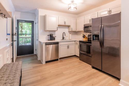 uma cozinha com um frigorífico de aço inoxidável e armários brancos em Coastal Luxe Villa by the Beach em Hilton Head Island