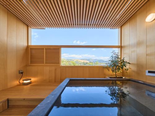 a swimming pool in a room with a large window at Hotel New Wakasa in Nara