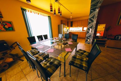 a dining room with a glass table and chairs at Aqua Villa in Siófok