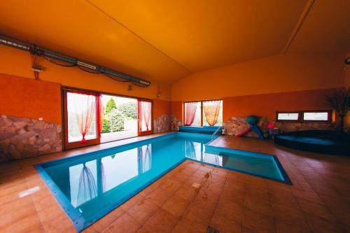 a swimming pool in a room with two windows at Aqua Villa in Siófok