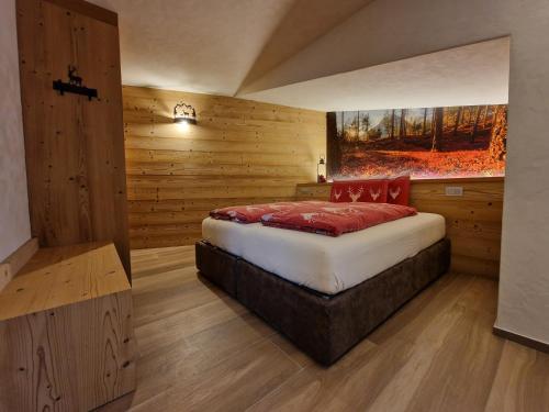 a bedroom with a bed in a room with wooden walls at Oga Sweet Home in Oga