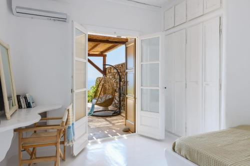 ein Schlafzimmer mit weißen Wänden, einem Bett und einer Tür in der Unterkunft Villa Sea Angels in Kalafatis