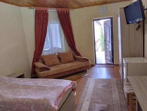 sala de estar con sofá y puerta corredera en В Гостях на Иссык-Куле, en Cholpon-Ata