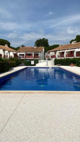 une grande piscine bleue en face de certaines maisons dans l'établissement Charmant T2 avec grande terrasse et confort 3 étoiles, à La Grande Motte