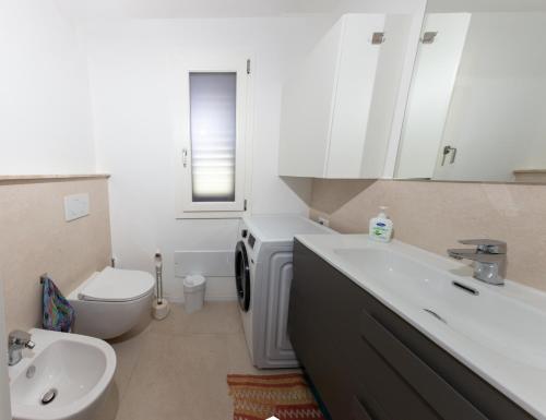 een witte badkamer met een wastafel en een toilet bij Villino Marigia in Geremèas