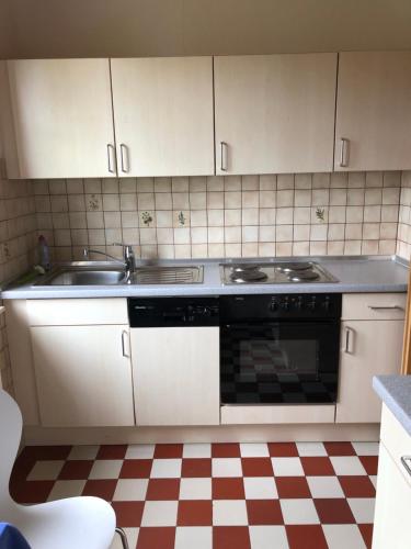 een keuken met een wastafel en een fornuis bij Ferienwohnung am Donauradwanderweg in Riedlingen