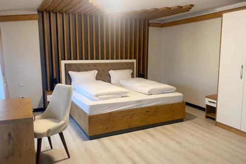 a bedroom with a bed and a chair in it at Spreehotel Spremberg in Spremberg