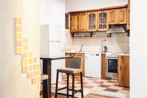 a kitchen with wooden cabinets and a counter with a stool at Apartments Art in Ulcinj