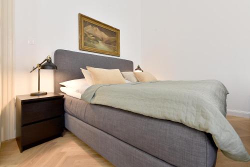 um quarto com uma cama cinzenta e uma mesa de cabeceira em Apartmán s balkónom em Trenčín