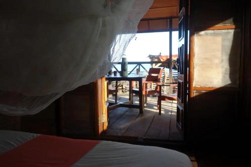 a bedroom with a view of a deck with a table at Robinson's Hut in Bure Town
