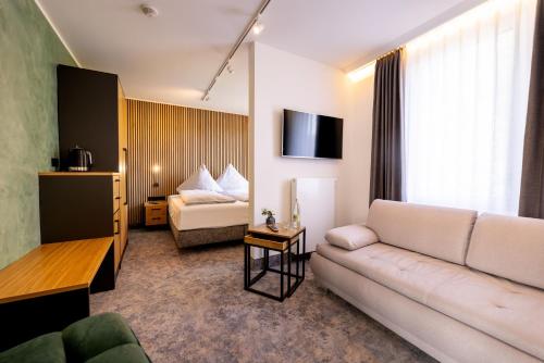 a living room with a couch and a bed at Hotel Südblick in Norderney