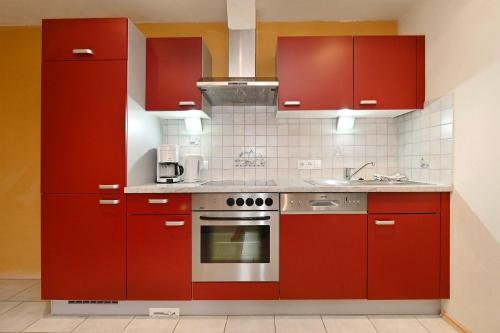 a kitchen with red cabinets and a stove at Ferienhaus Schwarzhans in Schruns-Tschagguns