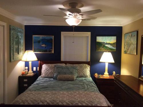 a bedroom with blue walls and a bed with two lamps at Spacious Light & Bright Private Apartment in Great Falls