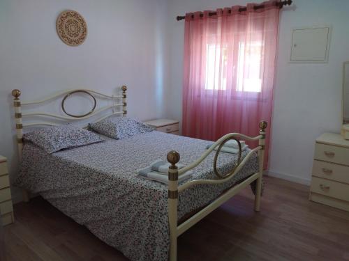 a bedroom with a bed and a pink curtain at Casa Júlia in Fonte Errada