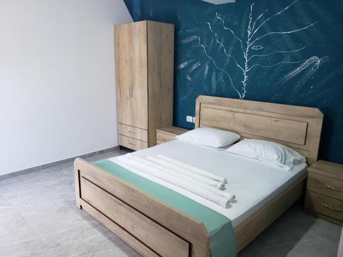 sypialnia z dużym łóżkiem z drewnianym zagłówkiem w obiekcie Villa Luan Ksamil w mieście Ksamil