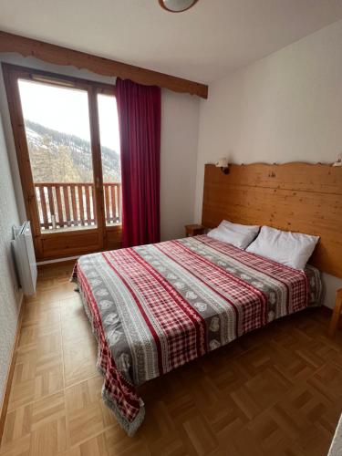 une chambre avec un lit et une grande fenêtre dans l'établissement Les Gentianes 1800, à Puy-Saint-Vincent