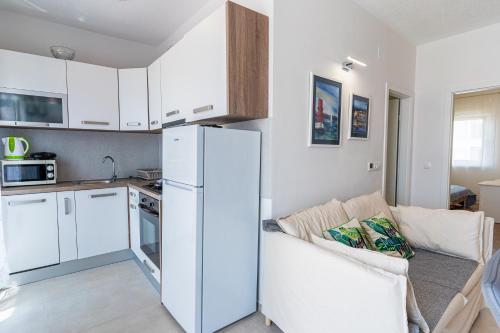 - une cuisine avec un réfrigérateur blanc dans le salon dans l'établissement Apartments Tatjana II, à Cres