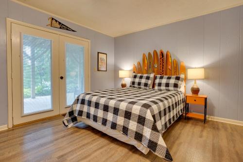 a bedroom with a bed with a checkered blanket at Lakefront Cadiz Home with Hot Tub! in Cadiz