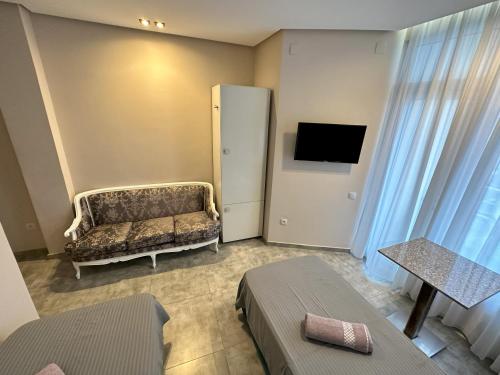 a hotel room with a couch and a television at National+ in Ureki