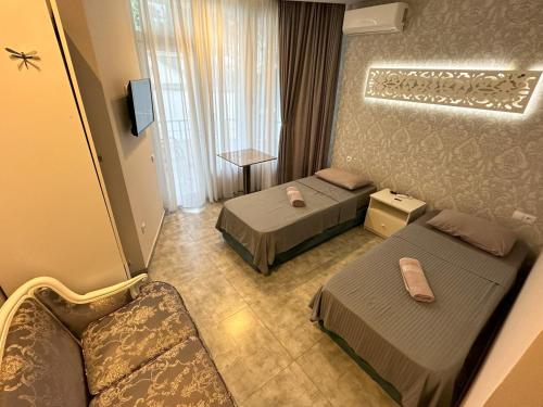 a hotel room with two beds and a couch at National+ in Ureki