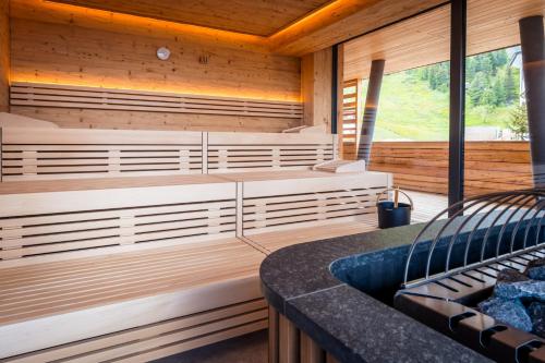a sauna with a tub in a wooden cabin at Alpin Peaks in Turracher Hohe