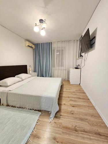 a bedroom with a bed and a flat screen tv at Apartment on Constantin Negruzzi in Chişinău