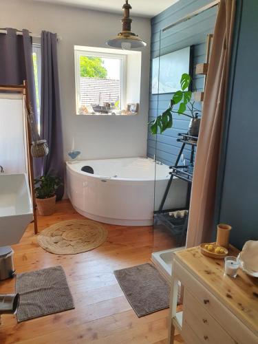 La grande salle de bains est pourvue d'une baignoire et d'une fenêtre. dans l'établissement La ferme de Lec'h Hameury, à Plestin-les-Grèves