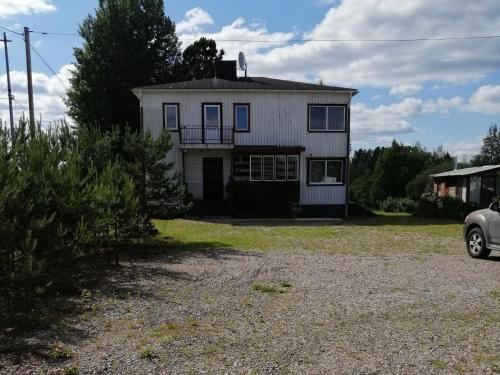 a white house with a car parked in front of it at Sangis Haparandavägen 11 in Sangis