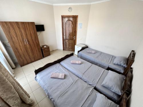 a bedroom with two beds and a wooden cabinet at National+ in Ureki