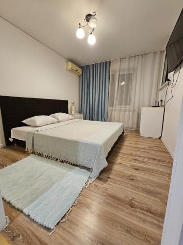 a bedroom with a large bed and a wooden floor at Apartment on Constantin Negruzzi in Chişinău